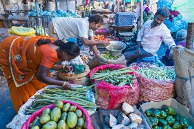 Belgesel yayın görüntü. Kimliği belirsiz bir Hint Tamil Nadu küçük kırsal köy pazarında meyve ve sebze onun dükkanında.