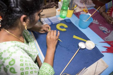 Belgesel yayın. Yaklaşık, Puduchery, Pondichery, Tamil Nadu, Hindistan - 2018 Mart. Kimliği belirsiz kadın kadın sanatçı el ile jewelleries kağıt olun. Küpe, kolye, çiçek. Kağıt geri dönüşüm ile.