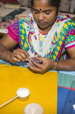 Belgesel yayın. Yaklaşık, Puduchery, Pondichery, Tamil Nadu, Hindistan - 2018 Mart. Kimliği belirsiz kadın kadın sanatçı el ile jewelleries kağıt olun. Küpe, kolye, çiçek. Kağıt geri dönüşüm ile.