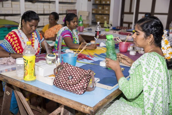 Belgesel yayın. Yaklaşık, Puduchery, Pondichery, Tamil Nadu, Hindistan - 2018 Mart. Kimliği belirsiz kadın kadın sanatçı el ile jewelleries kağıt olun. Küpe, kolye, çiçek. Kağıt geri dönüşüm ile.