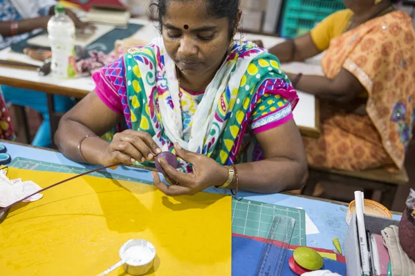 Belgesel yayın. Yaklaşık, Puduchery, Pondichery, Tamil Nadu, Hindistan - 2018 Mart. Kimliği belirsiz kadın kadın sanatçı el ile jewelleries kağıt olun. Küpe, kolye, çiçek. Kağıt geri dönüşüm ile.