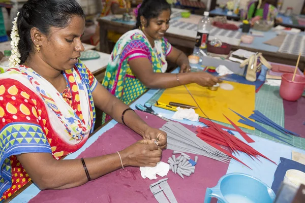 Belgesel yayın. Yaklaşık, Puduchery, Pondichery, Tamil Nadu, Hindistan - 2018 Mart. Kimliği belirsiz kadın kadın sanatçı el ile jewelleries kağıt olun. Küpe, kolye, çiçek. Kağıt geri dönüşüm ile.