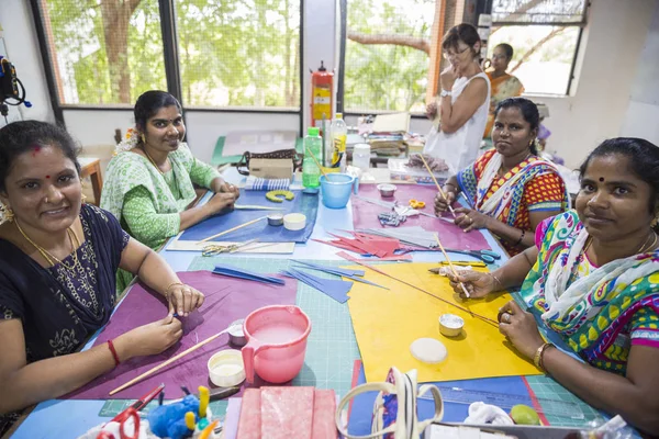 Belgesel yayın. Yaklaşık, Puduchery, Pondichery, Tamil Nadu, Hindistan - 2018 Mart. Kimliği belirsiz kadın kadın sanatçı el ile jewelleries kağıt olun. Küpe, kolye, çiçek. Kağıt geri dönüşüm ile.
