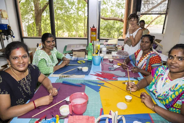 Belgesel yayın. Yaklaşık, Puduchery, Pondichery, Tamil Nadu, Hindistan - 2018 Mart. Kimliği belirsiz kadın kadın sanatçı el ile jewelleries kağıt olun. Küpe, kolye, çiçek. Kağıt geri dönüşüm ile.