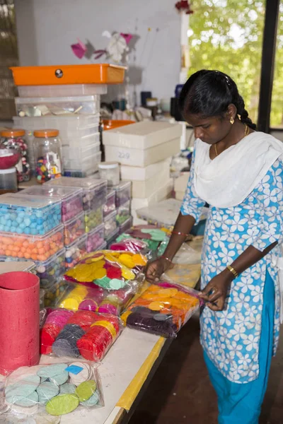 Belgesel yayın. Yaklaşık, Puduchery, Pondichery, Tamil Nadu, Hindistan - 2018 Mart. Kimliği belirsiz kadın kadın sanatçı el ile jewelleries kağıt olun. Küpe, kolye, çiçek. Kağıt geri dönüşüm ile.
