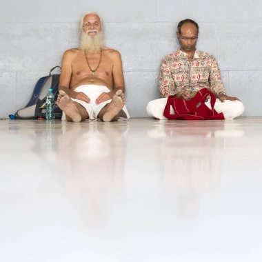 Belgesel yayın. Ashram'daki Sri Ramana Maharshi, Tiruvannamalai, Tamil Nadu, Hindistan - Mart yaklaşık, 2018. Kimliği belirsiz bir kadın ve maneviyat ashram meditasyon yapmak için katta oturan adam.