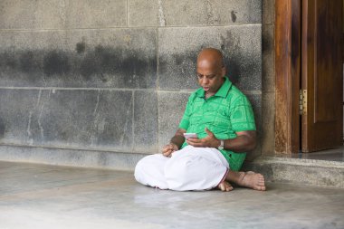 Belgesel yayın. Ashram'daki Sri Ramana Maharshi, Tiruvannamalai, Tamil Nadu, Hindistan - Mart yaklaşık, 2018. Kimliği belirsiz bir kadın ve maneviyat ashram meditasyon yapmak için katta oturan adam.