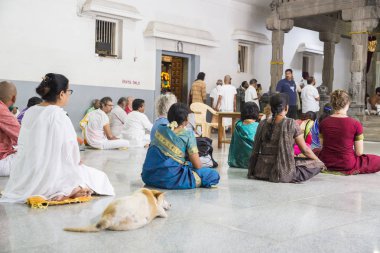 Belgesel yayın. Ashram'daki Sri Ramana Maharshi, Tiruvannamalai, Tamil Nadu, Hindistan - Mart yaklaşık, 2018. Kimliği belirsiz bir kadın ve maneviyat ashram meditasyon yapmak için katta oturan adam.