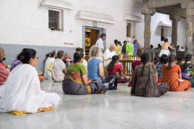 Belgesel yayın. Ashram'daki Sri Ramana Maharshi, Tiruvannamalai, Tamil Nadu, Hindistan - Mart yaklaşık, 2018. Kimliği belirsiz bir kadın ve maneviyat ashram meditasyon yapmak için katta oturan adam.