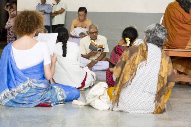 Belgesel yayın. Ashram'daki Sri Ramana Maharshi, Tiruvannamalai, Tamil Nadu, Hindistan - Mart yaklaşık, 2018. Kimliği belirsiz bir kadın ve maneviyat ashram meditasyon yapmak için katta oturan adam.