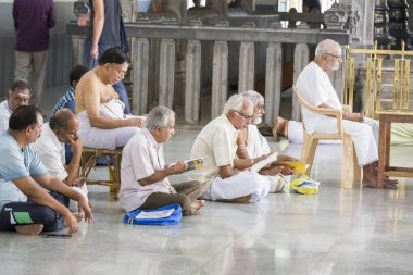 Belgesel yayın. Ashram'daki Sri Ramana Maharshi, Tiruvannamalai, Tamil Nadu, Hindistan - Mart yaklaşık, 2018. Kimliği belirsiz bir kadın ve maneviyat ashram meditasyon yapmak için katta oturan adam.