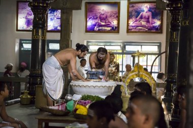 Belgesel yayın. Ashram'daki Sri Ramana Maharshi, Tiruvannamalai, Tamil Nadu, Hindistan - Mart yaklaşık, 2018. Kimliği belirsiz bir kadın ve erkek, meditasyon yapmak için ashram törenle dua, maneviyat.