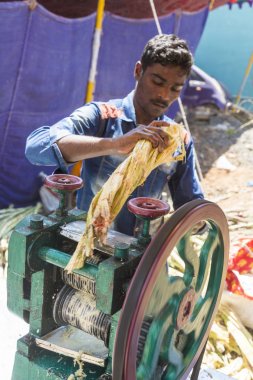 Belgesel yayın. Yaklaşık, Puduchery, Pondichery, Tamil Nadu, Hindistan - 2018 Mart. Kimliği belirsiz erkek işçi ayıklamak kamışı suyu