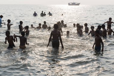 Kimliği belirsiz Hint hacı kadın erkek çocuk aile sahilde, denize arıtma arıtma için tapınağın gitmeden önce banyo grubu.