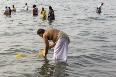 Kimliği belirsiz Hint hacı kadın erkek çocuk aile sahilde, denize arıtma arıtma için tapınağın gitmeden önce banyo grubu.