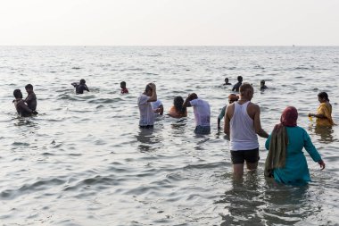 Kimliği belirsiz Hint hacı kadın erkek çocuk aile sahilde, denize arıtma arıtma için tapınağın gitmeden önce banyo grubu.