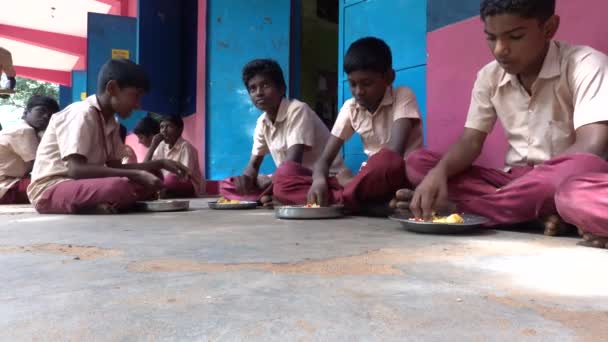 2018年12月 インド プドゥカリー 外の階に制服を着た未確認の貧しい同級生の子供たちマサラとご飯を右手で食べながら食堂でのランチタイム — ストック動画