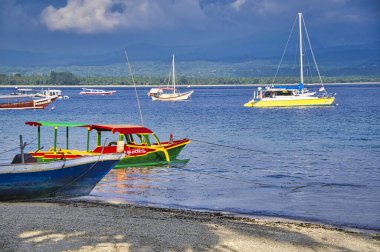 Bulutlu gökyüzü, Gili Trawangan, Lombok, Endonezya ile mavi deniz tropikal plajda tekne güzel görünümü
