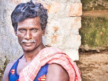 PUDUCHERRY, İNDİA - Aralık 2018. Köyün sokaklarında gülen yüzlü 40-50 yaşındaki Hintli bir adamın portresi. Canlı renklerle ön görünüm