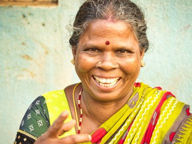 PUDUCHERRY, İNDİA - Aralık 2018. 50-60 yaşlarında, harika gülümseyen yüzlü bir kadının portresi, köyün sokaklarında. Canlı renklerle ön görünüm