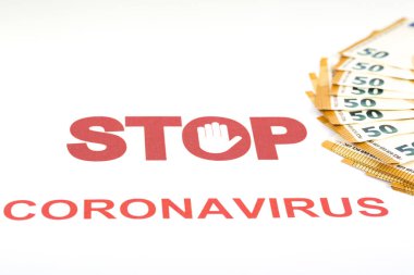 Covid-19 'un Avrupa' nın para bölgesi üzerindeki mali etkisi. Beyaz arka planda dur işareti ve kırmızı harflerle yazılmış koronavirüsle dolu elli avroluk banknotlar.