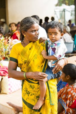 Puducherry, Tamil Nadu, Hindistan - Mart 2020. Bir devlet hastanesi girişi. Silahlı bir kadın çocuk sosyal bir uzaklık olmadan içeri girmeyi bekliyor..