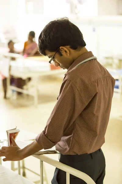 PUDUCHERRY, INDIA - M ARCH Circa, 2020. Doctor without protective suit and mask is checking the infected aging child patient in the hospital room, by keeping social distance