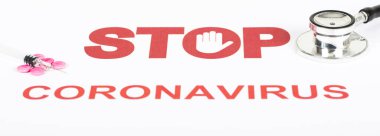 Roman Covid-19, Çin 'den Wuhan virüsü konsepti. Beyaz arkaplanda dur işareti olan kırmızı harfli Coronavirus metni. Uzayı kopyala Termometre hapları ve şırıngayla. Panoramik pankart boyutu