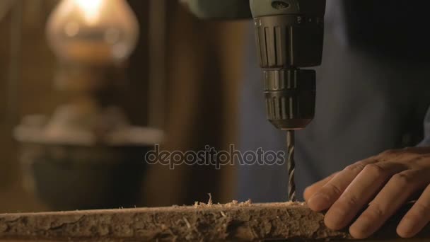 The carpenter makes a hole in the Board drill. master works in the Studio tool. — Stock Video