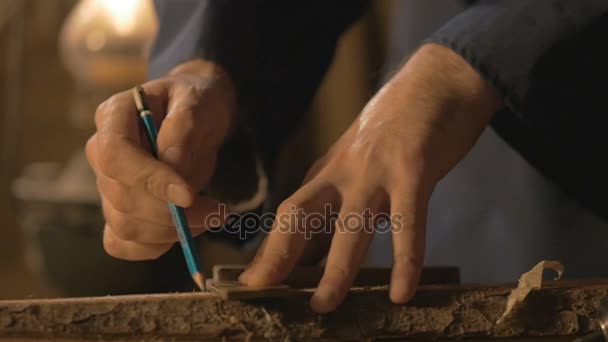 Maestro carpintero hace la cocción en el tablero con un lápiz, dibuja, herramienta de trabajo del artesano en el taller . — Vídeos de Stock