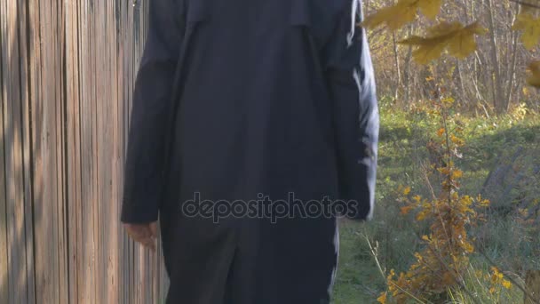 Um homem, caminhando ao longo da estrada na aldeia no dia de outono. Foco superficial . — Vídeo de Stock
