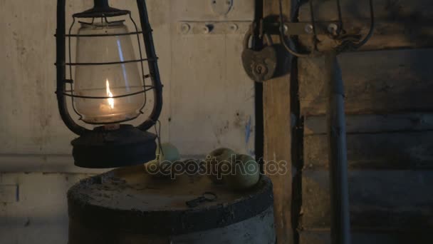 Антикварна лампа зі свічкою на дерев'яному столі з яблуками ввечері, фермер приніс лампу, ліхтар, освітлений кімнатою 4K — стокове відео