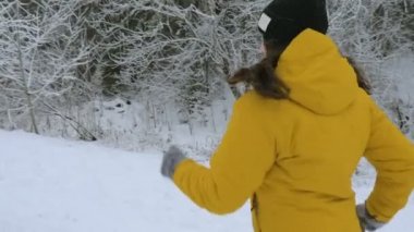 Kız kış orman yolu üzerinde çalışır. Ayak closeup aşağıdan