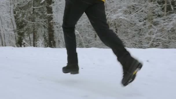 La ragazza corre per strada nella foresta invernale. Piedi primo piano dal basso — Video Stock