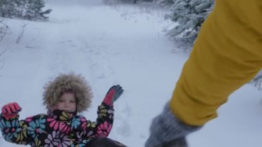 Kadın kış Park'ta bir çocukla bir kızak çekme. Steadicam hareket, 4k