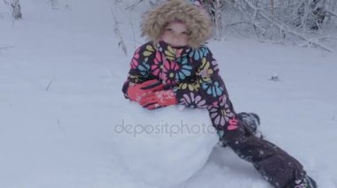 Steadicam. Bir kız bir kardan adam karda kışın sculpts..