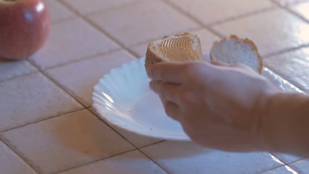 准备烤面包、 黄油和果酱的女人手揉黄油涂在一片烤面包上。关闭。4 k — 图库视频影像