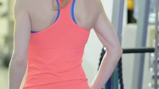 Girl tying hair in the hall to the fitness center before practice. Close-up — Stock Video