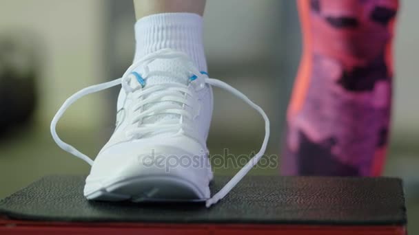 Dziewczyna wiąże sznurówki w centrum fitness. Szczelnie-do góry — Wideo stockowe