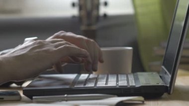 adam kahve ile laptop yazarak