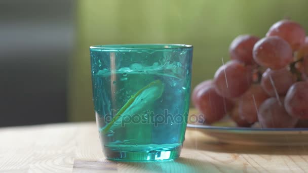 En un vaso de cristal azul gota de limón — Vídeo de stock