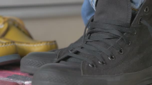 Молодой человек, завязывающий шнурки в туфли — стоковое видео