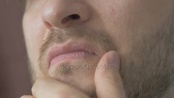 Jovem bonito com uma barba acariciando sua barba pensa — Vídeo de Stock