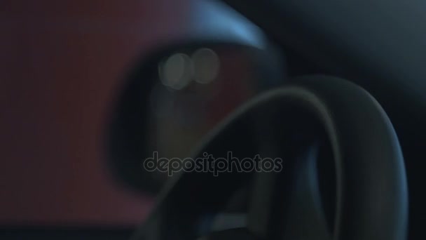 Male hand operates steering wheel of moving vehicle in city lights at night. Right side view — Stock Video