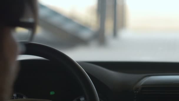 Ein Mann, der das Auto in einer Tiefgarage lenkt. Nahaufnahme. Bokeh-Hintergrund — Stockvideo