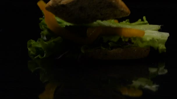 La hamburguesa cae en acción lenta sobre la mesa — Vídeos de Stock