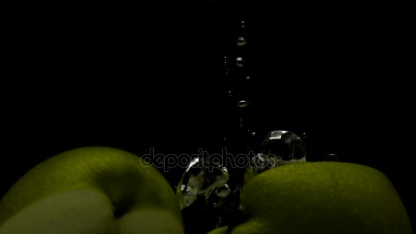 Pomme verte au ralenti super tomber dans l'eau sur fond noir 