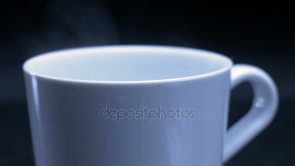White cup of tea or coffee with steam on black background. Right side. 4K — Stock Video
