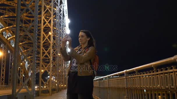 Žena dělat selfie na mobilním telefonu v Petrohradě, most v noci — Stock video