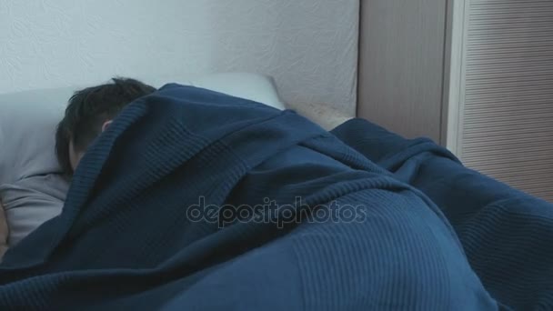 Мужчина спит в постели. the boy wake up from a nightmare — стоковое видео